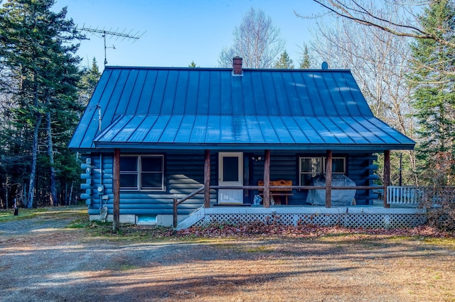 log home featuring a standing seam roof, covered porch, and log exterior