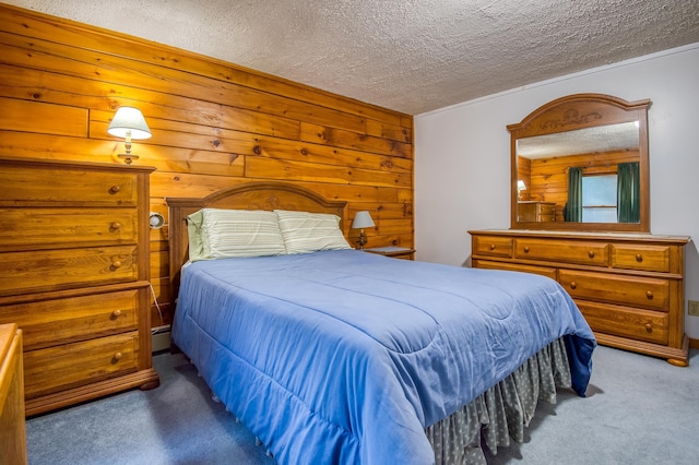 bedroom featuring carpet flooring, wood walls, baseboard heating, and a textured ceiling