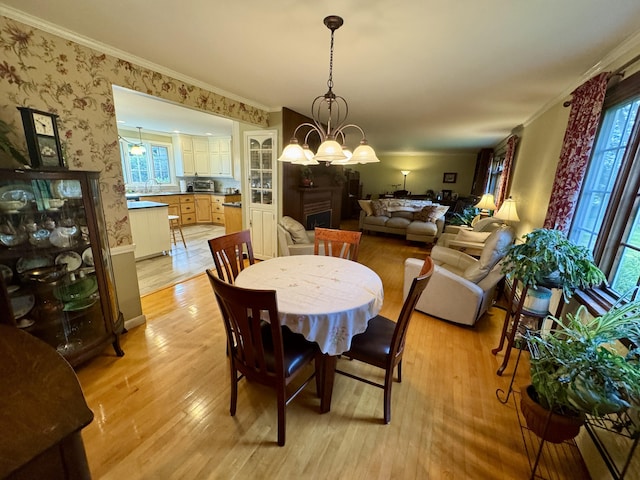 12 Hycrest Ln, Old Town, ME 04468 - dining space featuring wallpapered walls, ornamental molding, light wood-style floors, and a notable chandelier