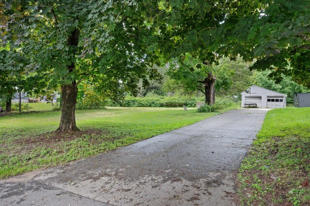 view of front facade with an outbuilding, a front yard, and a garage