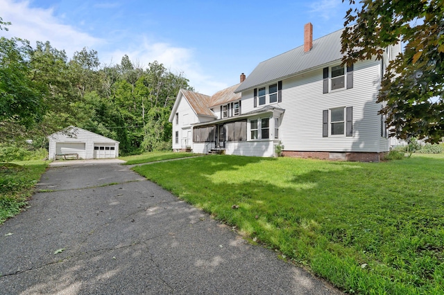 view of front facade with a garage, a front lawn, and an outdoor structure