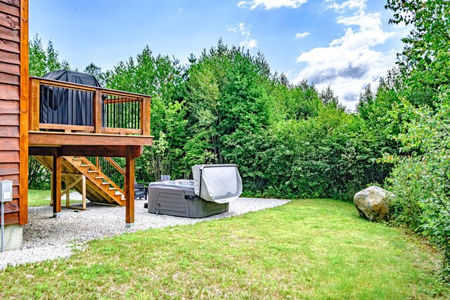 view of yard with a hot tub and a wooden deck