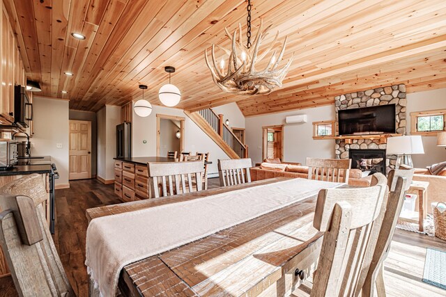 dining room with a fireplace, dark hardwood / wood-style floors, an AC wall unit, and wooden ceiling