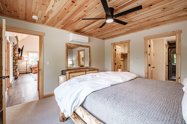 bedroom with ceiling fan, a wall mounted air conditioner, light hardwood / wood-style flooring, a walk in closet, and a closet