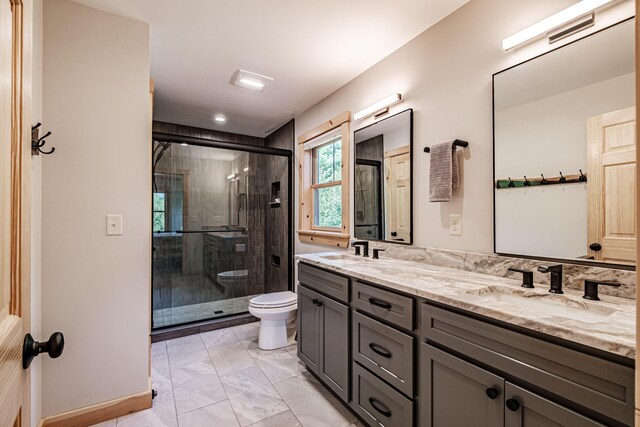 bathroom featuring vanity, toilet, and a shower with shower door