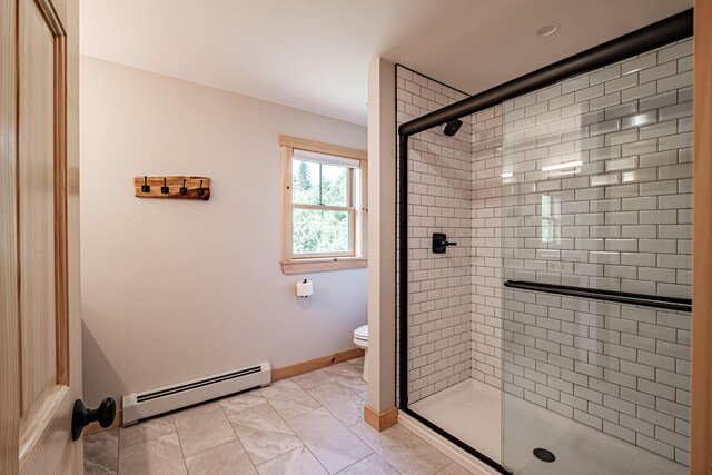 bathroom featuring toilet, baseboard heating, and walk in shower