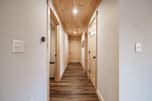 corridor with dark hardwood / wood-style floors and wooden ceiling