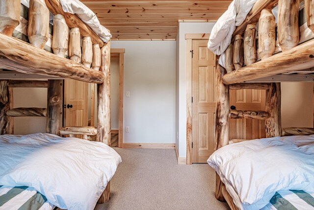 bedroom featuring wood ceiling and light carpet