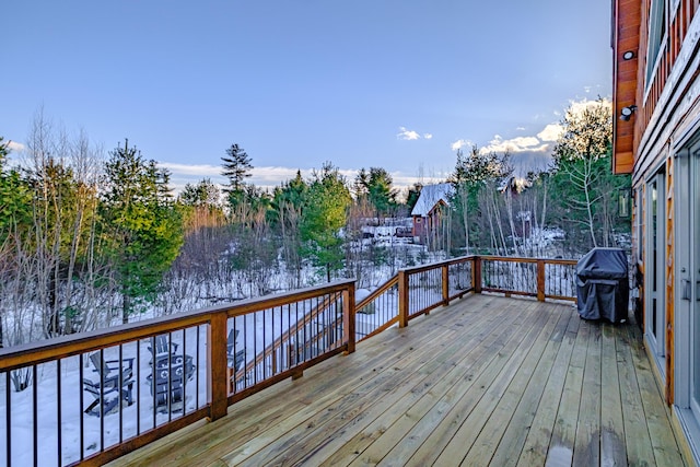 snow covered deck with a grill