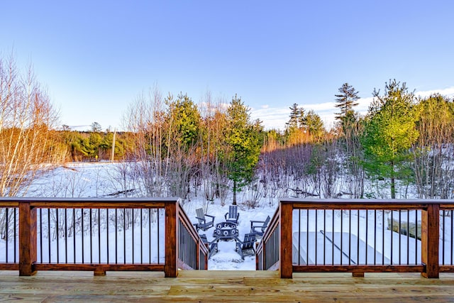 snow covered deck featuring an outdoor fire pit