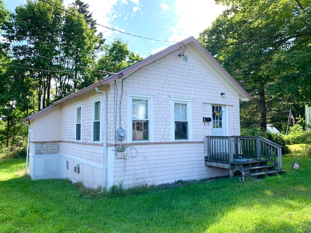 rear view of house featuring a lawn and a wooden deck