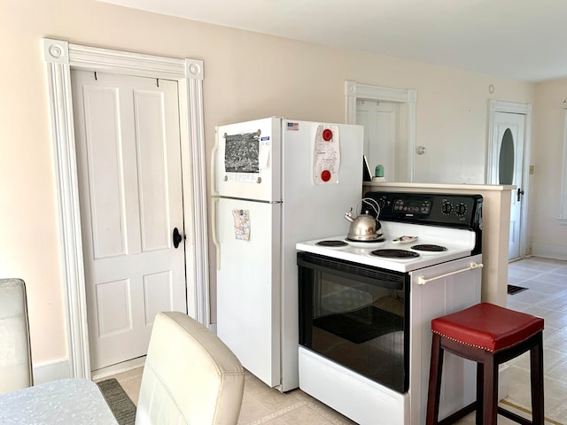 kitchen featuring light tile patterned flooring and white appliances