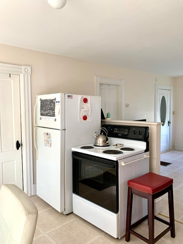 kitchen featuring light tile patterned floors and white electric range