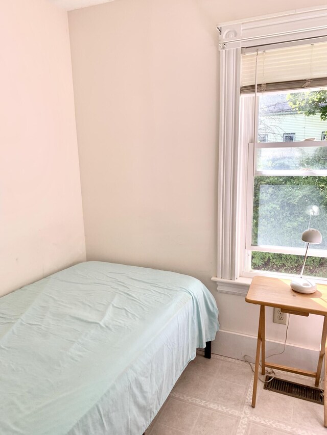 bedroom with light tile patterned flooring and multiple windows