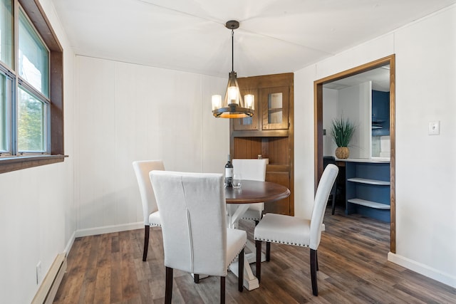 dining area featuring dark hardwood / wood-style floors, a baseboard radiator, and an inviting chandelier