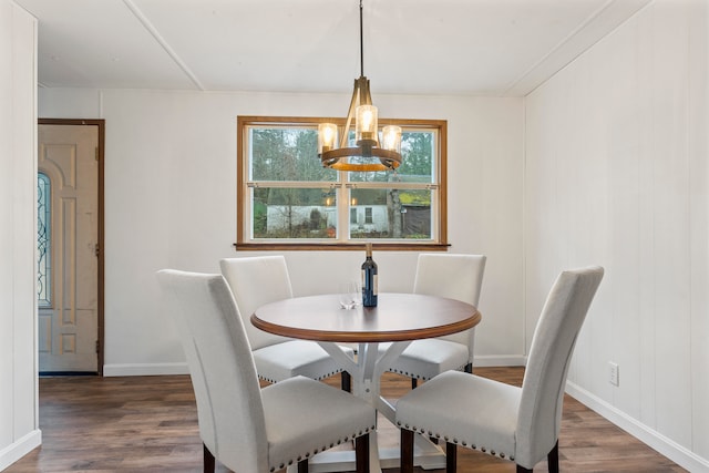 dining space with dark hardwood / wood-style floors, ornamental molding, and a notable chandelier