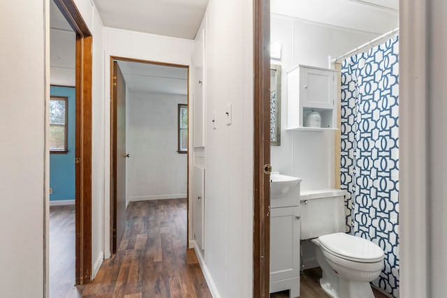 bathroom featuring toilet, vanity, and hardwood / wood-style floors