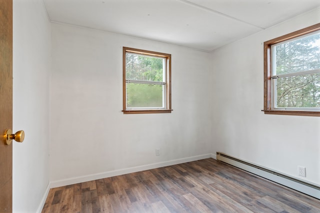 empty room featuring hardwood / wood-style floors and a baseboard radiator