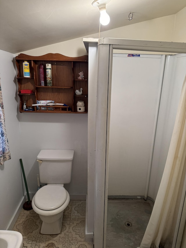 bathroom featuring walk in shower, lofted ceiling, and toilet