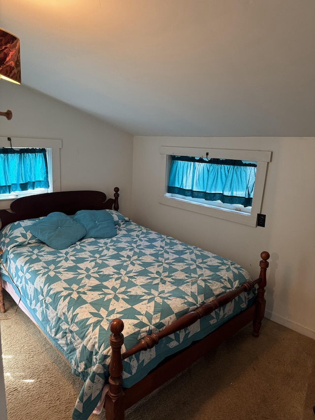 bedroom featuring vaulted ceiling, multiple windows, and carpet floors