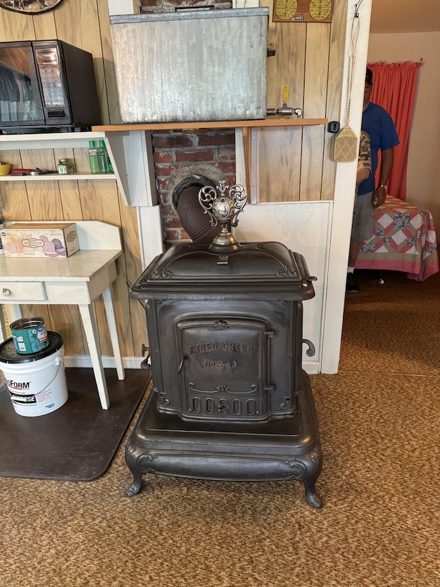 room details with a wood stove and carpet flooring