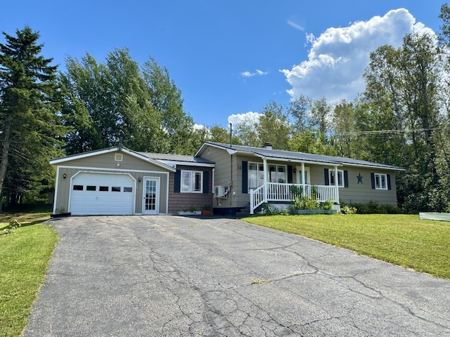 view of front of property featuring metal roof, a porch, aphalt driveway, an attached garage, and a front lawn