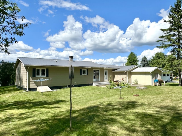 rear view of house featuring metal roof and a lawn