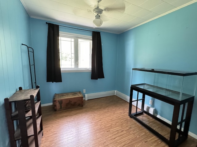 sitting room featuring crown molding, baseboards, and wood finished floors