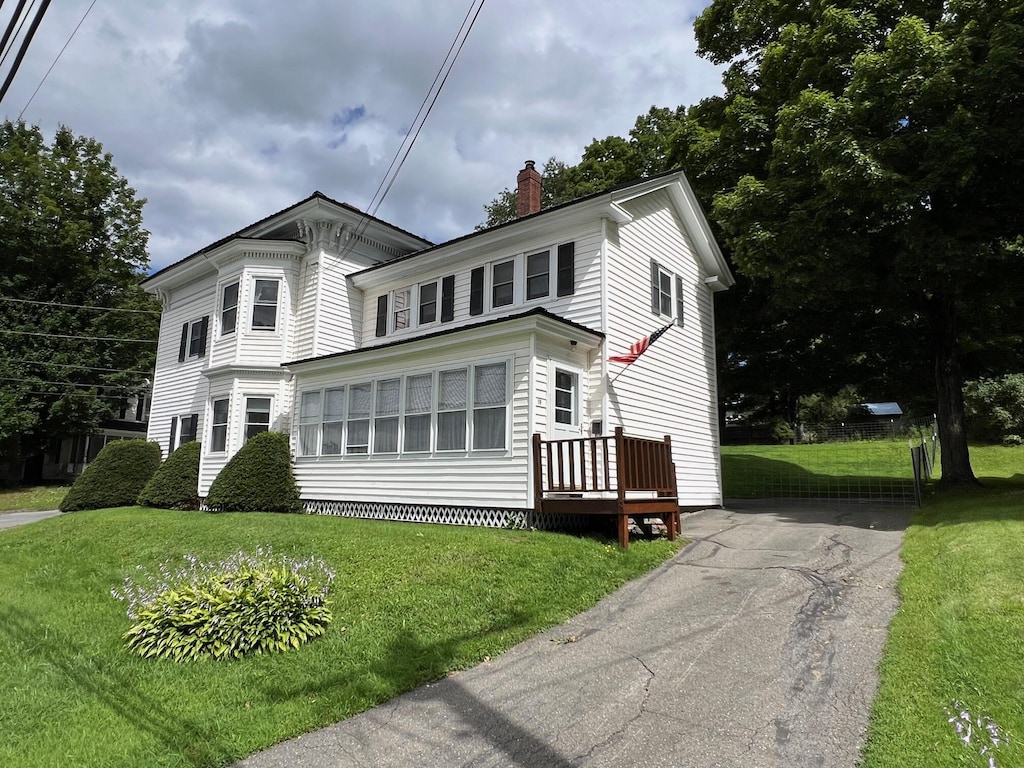 19 Pleasant St, Dexter, ME 04930 - view of front of home with aphalt driveway, a chimney, and a front yard
