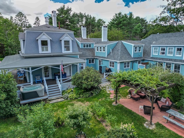 rear view of property featuring a patio, a porch, and a yard