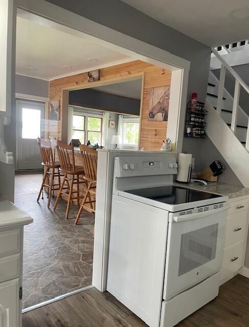 kitchen featuring a wealth of natural light, white cabinets, and white range with electric cooktop