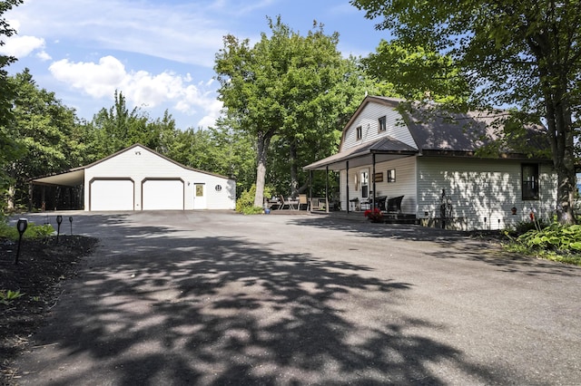 exterior space with a detached garage, an outdoor structure, and a gambrel roof