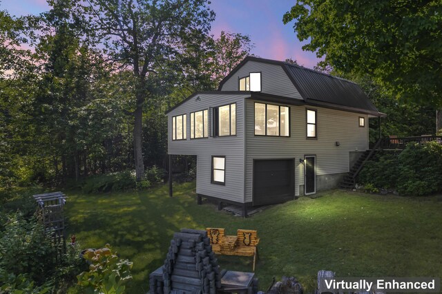 property exterior at dusk featuring a garage and a yard