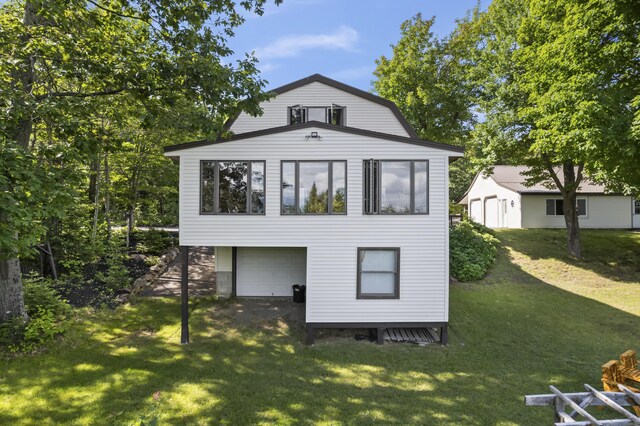 rear view of house with a garage and a yard