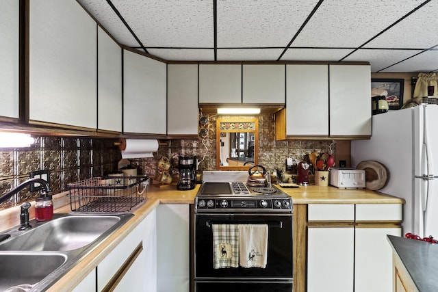 kitchen featuring white cabinets, backsplash, black / electric stove, and sink