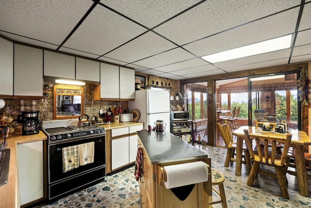 kitchen featuring light countertops, black / electric stove, stainless steel microwave, and freestanding refrigerator