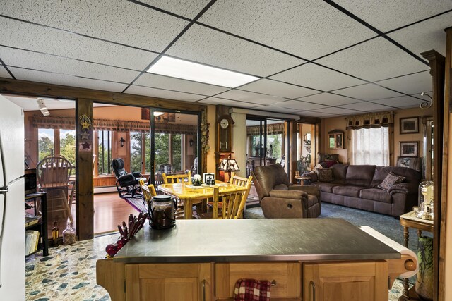 living room featuring a paneled ceiling and a baseboard heating unit