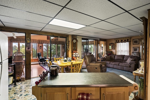 interior space featuring a baseboard heating unit and a drop ceiling