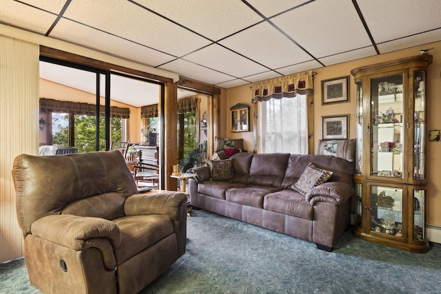 living area with a baseboard heating unit, dark colored carpet, and a paneled ceiling