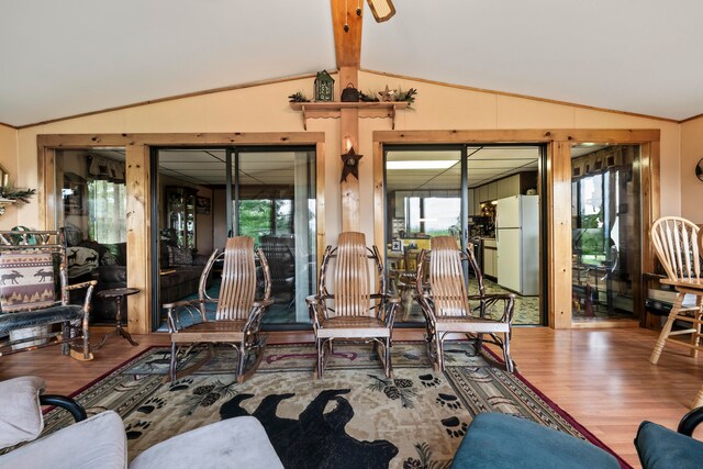 living room with hardwood / wood-style floors and vaulted ceiling with beams