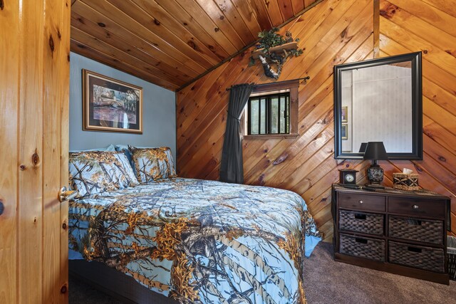 carpeted bedroom with wood walls, wooden ceiling, and vaulted ceiling