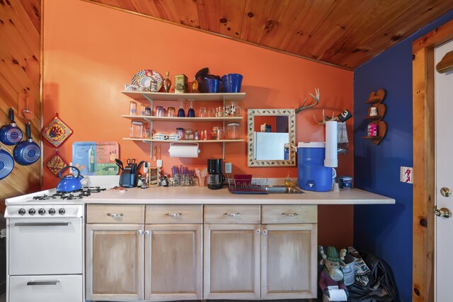 kitchen with white gas stove, wooden ceiling, light brown cabinetry, and vaulted ceiling