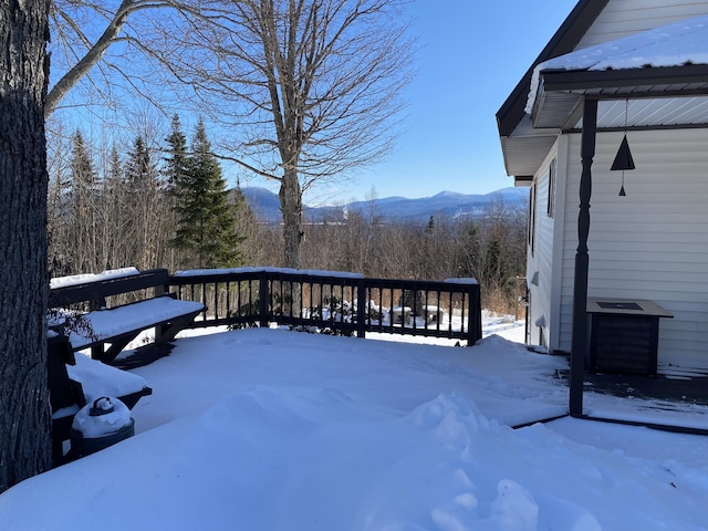 snow covered deck with a mountain view