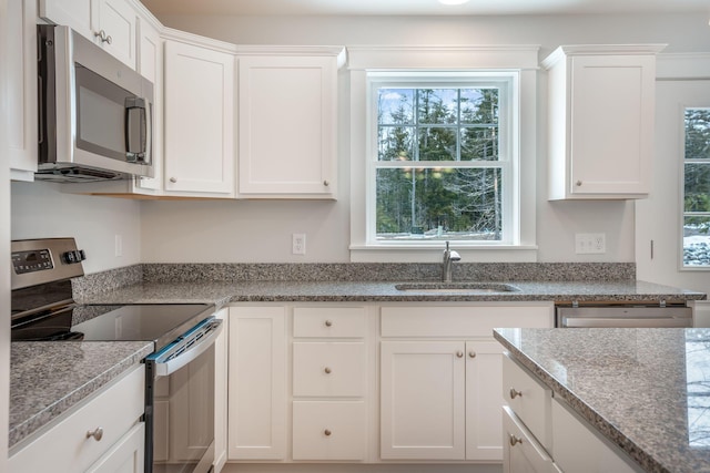 kitchen with sink, plenty of natural light, white cabinetry, and stainless steel appliances