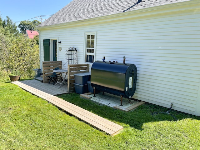 wooden terrace featuring area for grilling and a yard