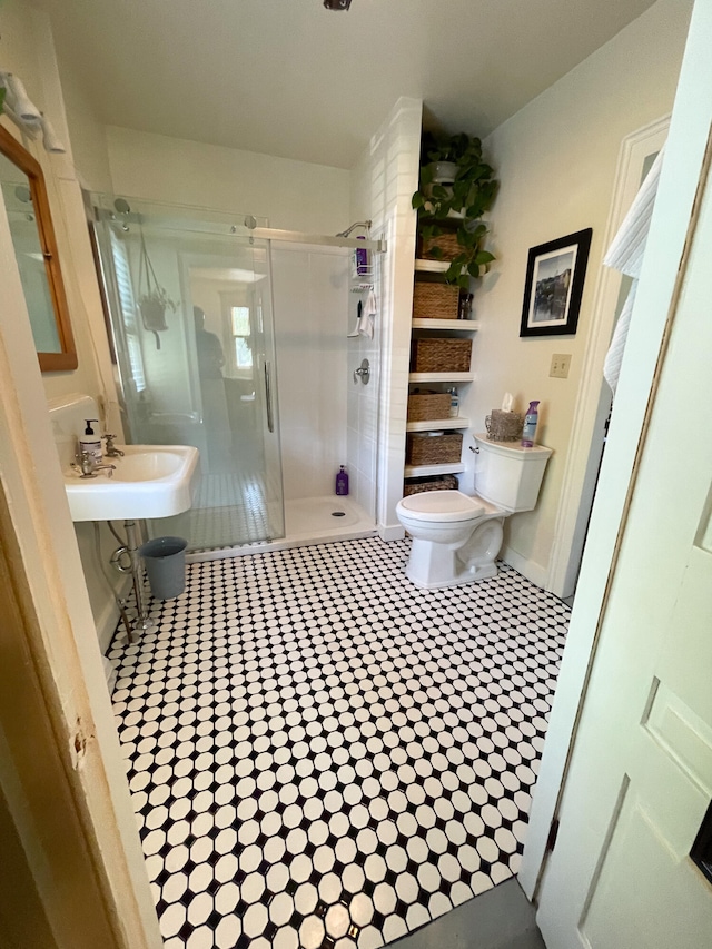 bathroom featuring tile patterned floors, sink, toilet, and a shower with door