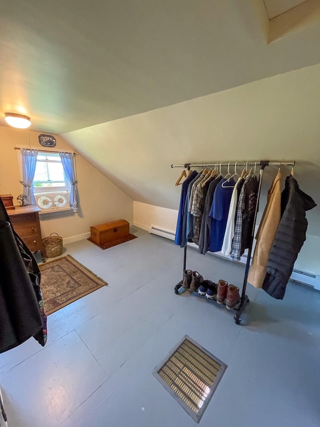 walk in closet featuring a baseboard heating unit and lofted ceiling