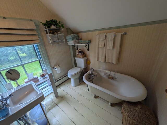 bathroom featuring toilet, a tub to relax in, hardwood / wood-style flooring, a baseboard heating unit, and lofted ceiling