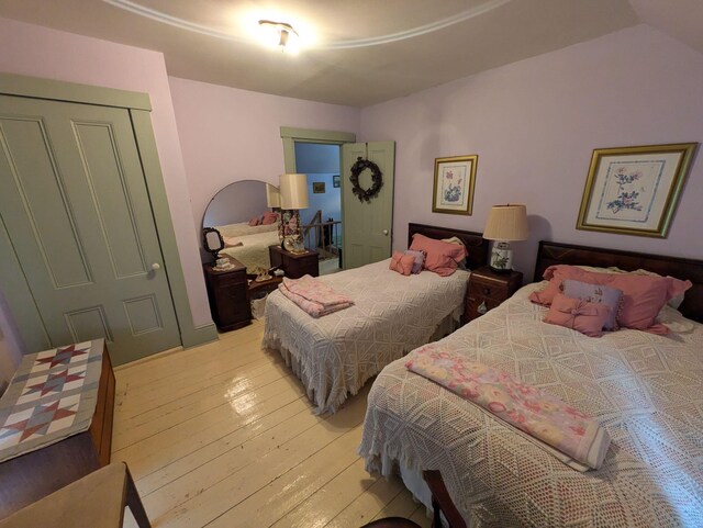 bedroom with light hardwood / wood-style floors and a closet