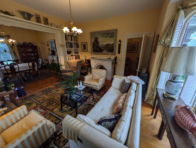 living room with hardwood / wood-style floors, plenty of natural light, and a notable chandelier